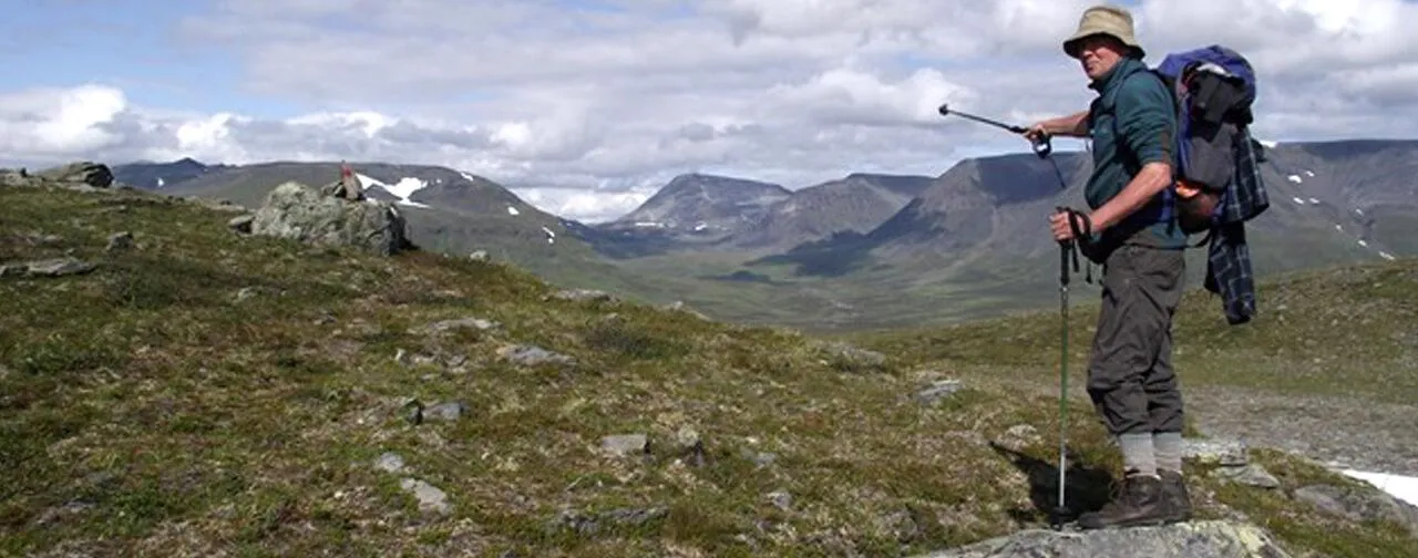 Alan Wilkinson pointing across a valley inside the Arctic Circle